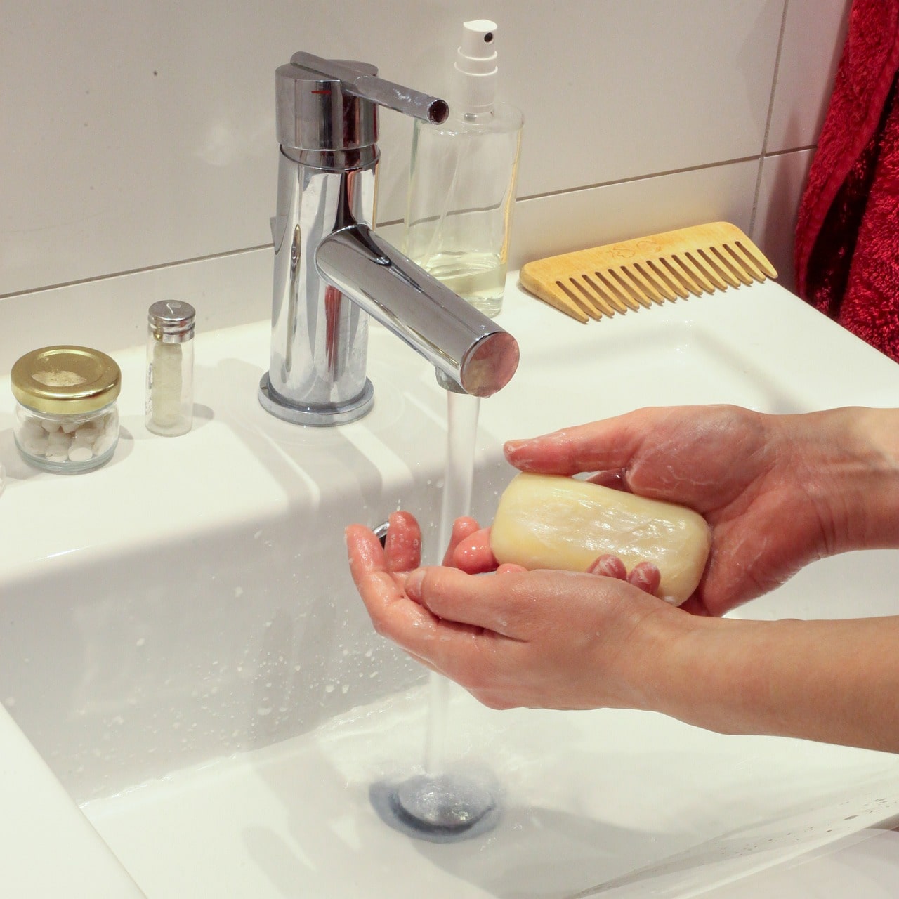 person washing their hands at the sink