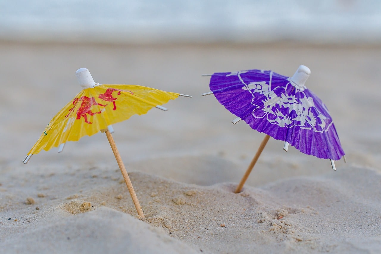 two small umbrellas stuck in the sand