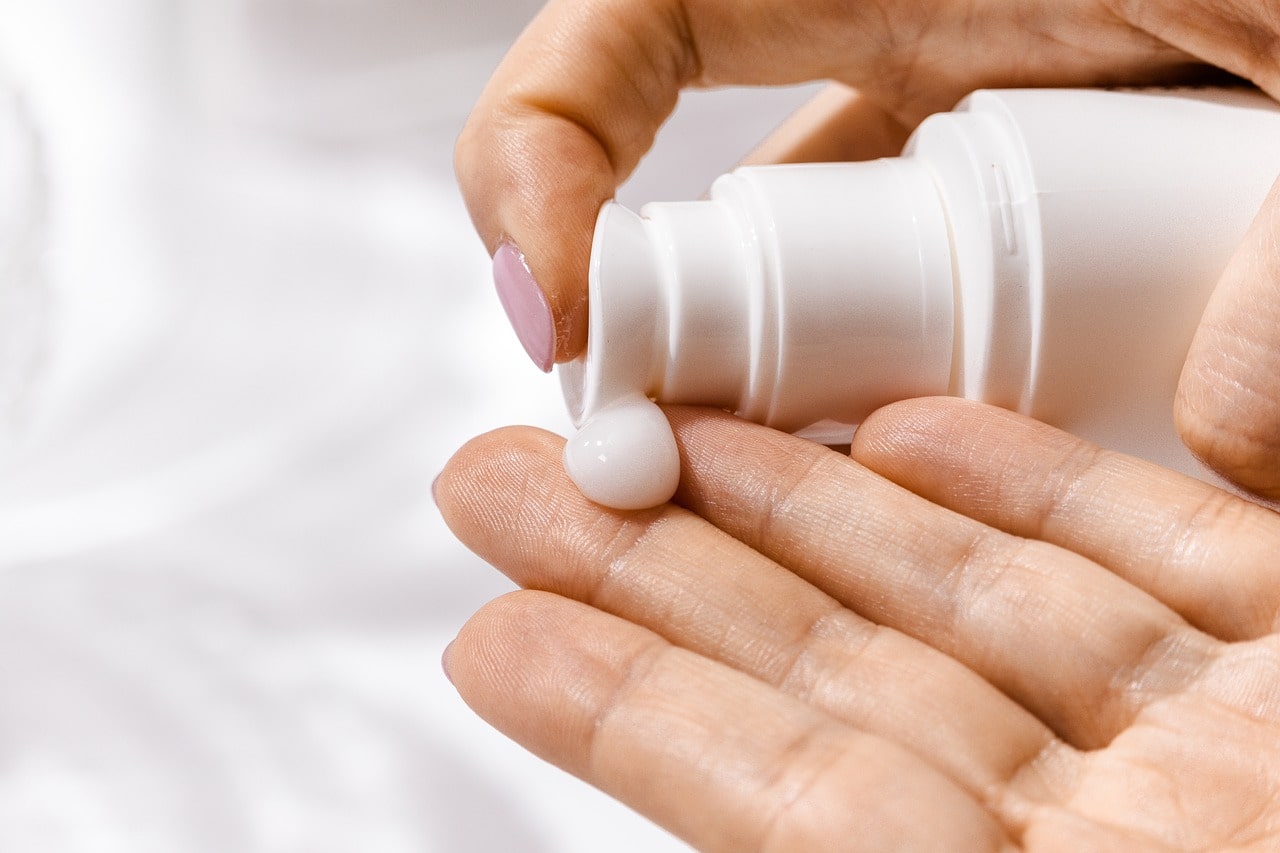 woman is applying sunscreen on her hand