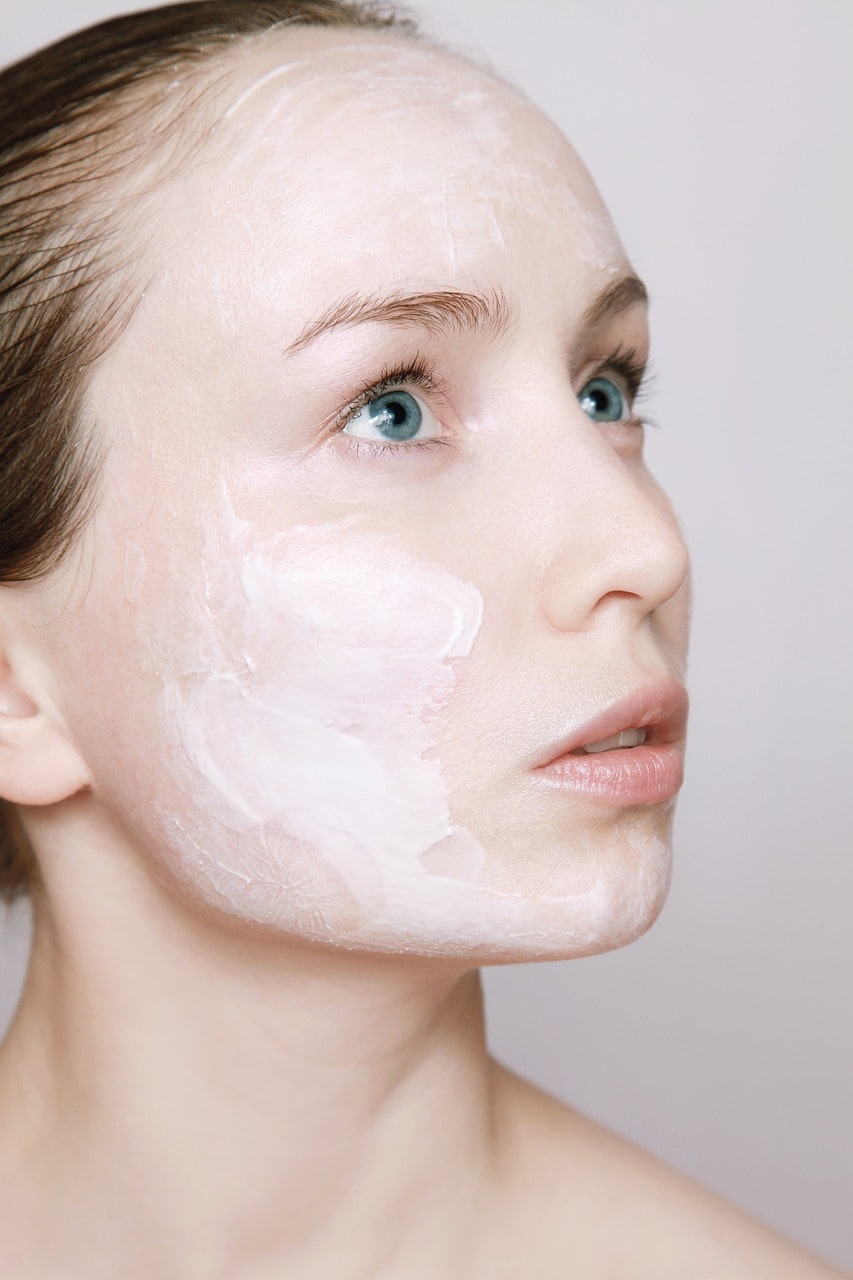 a woman applying sunscreen on her face