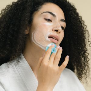 a woman gently massaging and applying a cleanser on her face