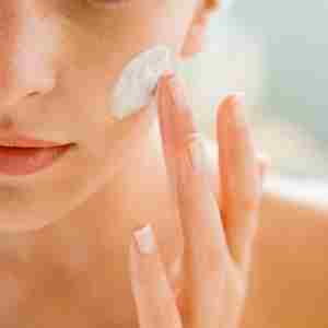 a woman is applying cleanser on her face