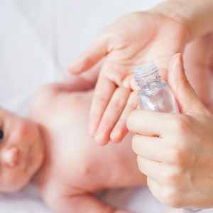 a mother puts baby oil on her baby